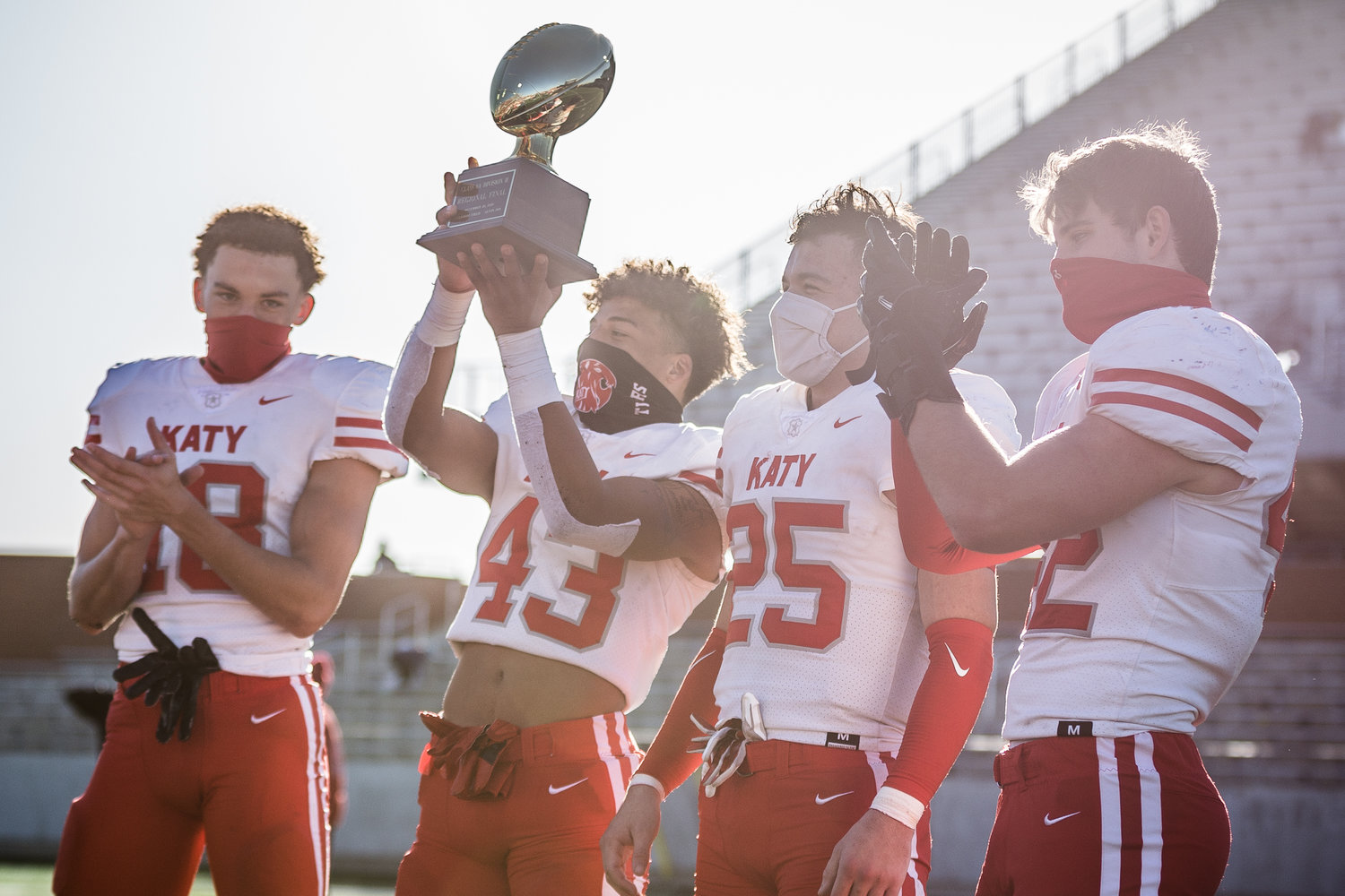 Katy High's team captains, from left to right Taylor Saulsberry, Dalton Johnson, Shepherd Bowling and Ty Kana, hold up the regional final trophy following the Tigers' 49-24 win over Shadow Creek on Dec. 26 at Freedom Field.